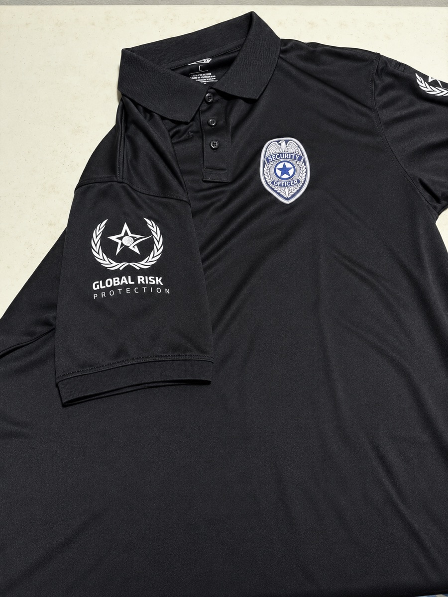 Polo negro con parche de seguridad y logo de compañía en la manga
